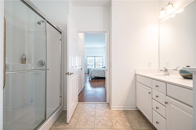 bathroom featuring tile patterned flooring, vanity, and a shower with door