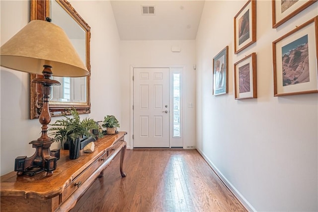 entrance foyer with hardwood / wood-style flooring, vaulted ceiling, and a healthy amount of sunlight