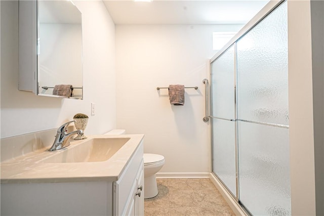 bathroom with vanity, a shower with shower door, and toilet