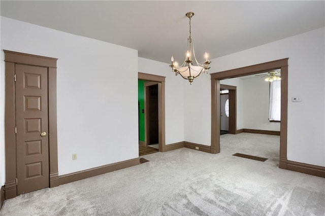 empty room with an inviting chandelier and carpet flooring