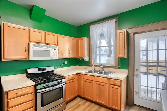 kitchen with light hardwood / wood-style flooring, sink, and stainless steel gas range