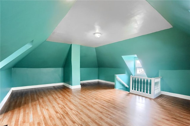 additional living space featuring lofted ceiling and hardwood / wood-style flooring