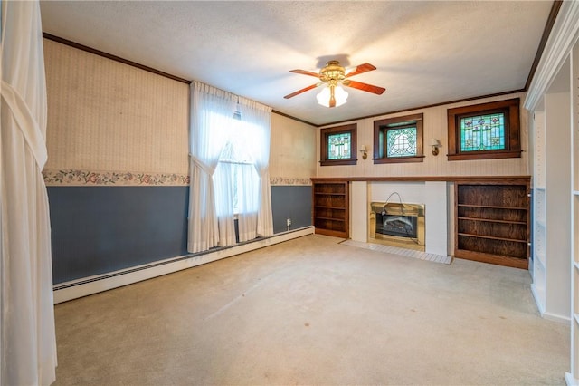 unfurnished living room with ceiling fan, ornamental molding, a textured ceiling, and a baseboard heating unit