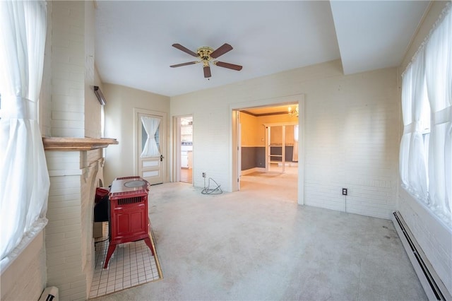 interior space featuring a wealth of natural light, a baseboard radiator, light colored carpet, and brick wall