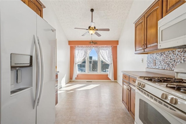 kitchen with ceiling fan, white appliances, a textured ceiling, and backsplash