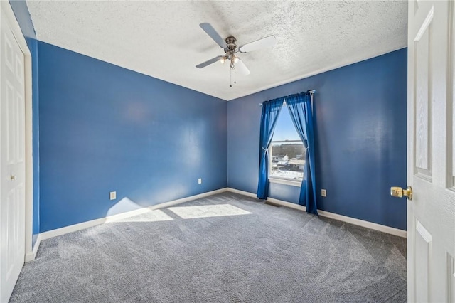 carpeted empty room with ceiling fan and a textured ceiling