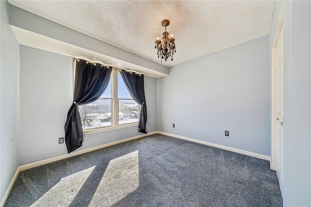 carpeted empty room featuring a textured ceiling and a notable chandelier