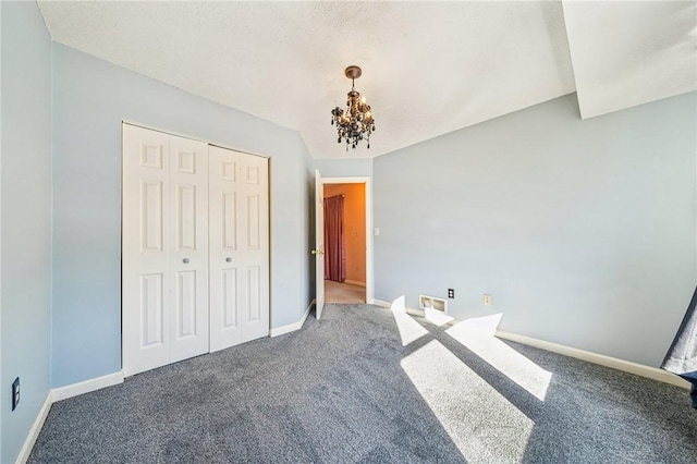 unfurnished bedroom featuring a notable chandelier, carpet floors, and a closet