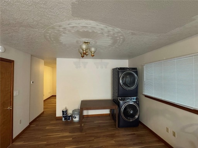 laundry area with stacked washer and dryer, hardwood / wood-style flooring, a notable chandelier, and a textured ceiling