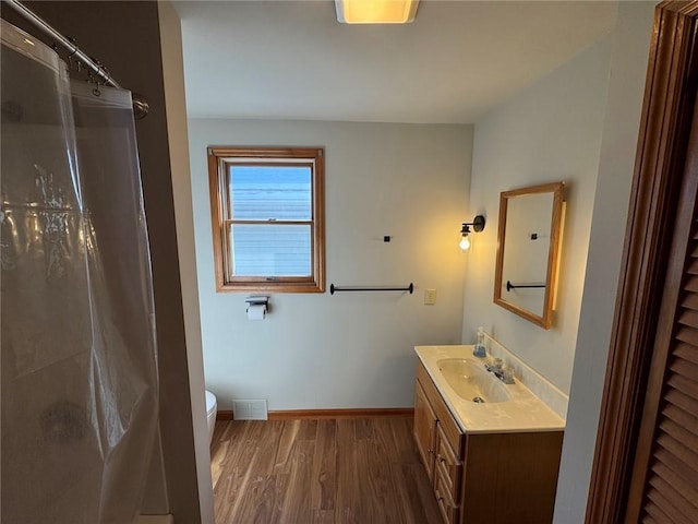 bathroom featuring vanity, hardwood / wood-style floors, toilet, and walk in shower