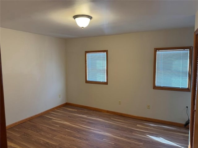 unfurnished room with dark wood-type flooring