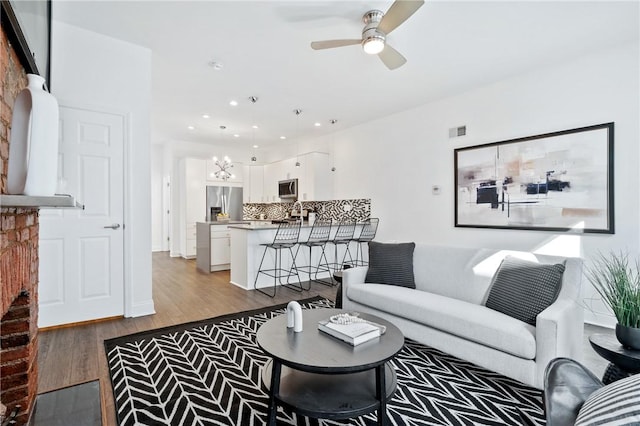 living room featuring ceiling fan and hardwood / wood-style floors