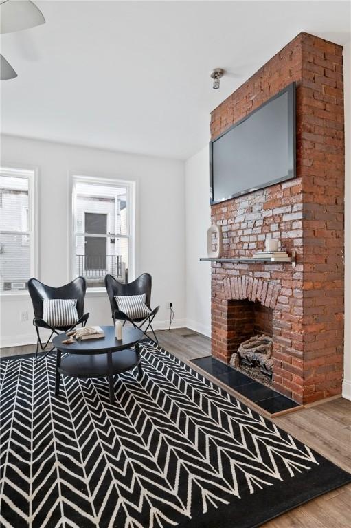 living room with wood-type flooring and a fireplace