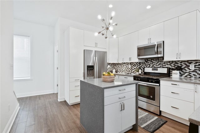 kitchen with white cabinetry, stainless steel appliances, and a center island