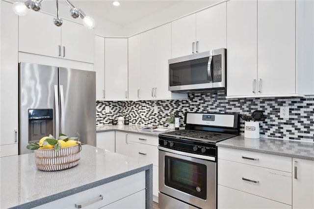 kitchen featuring backsplash, stainless steel appliances, white cabinets, and light stone countertops