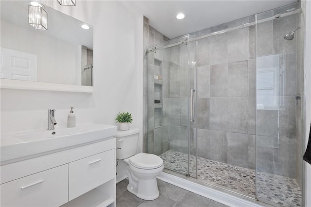 bathroom with vanity, a shower with shower door, and toilet