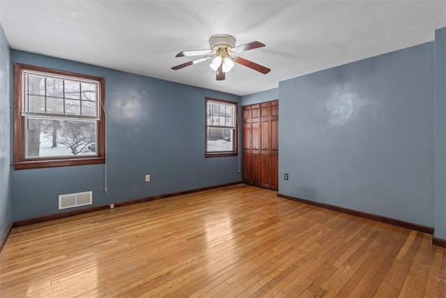 empty room with light hardwood / wood-style floors and ceiling fan