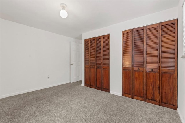 unfurnished bedroom featuring multiple closets and carpet