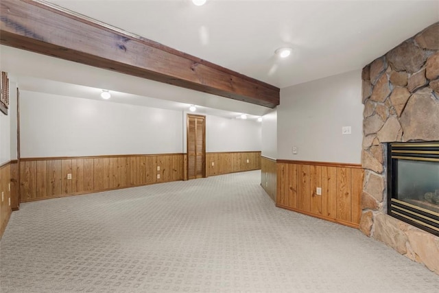 basement featuring light carpet and a fireplace