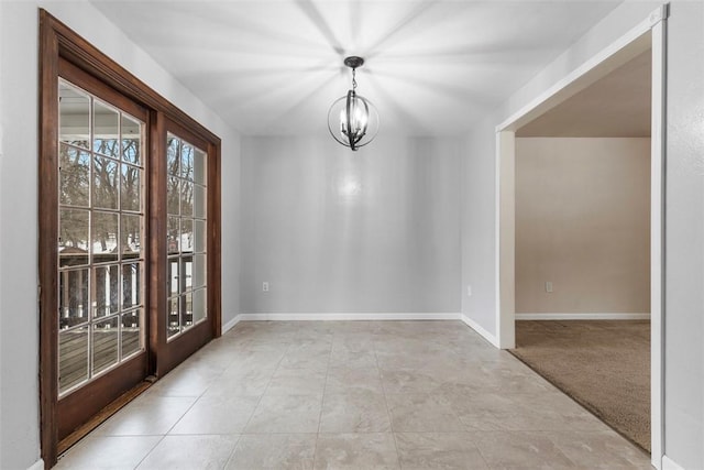 unfurnished dining area with a notable chandelier, light colored carpet, and french doors