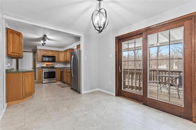 kitchen with stainless steel appliances, hanging light fixtures, and an inviting chandelier