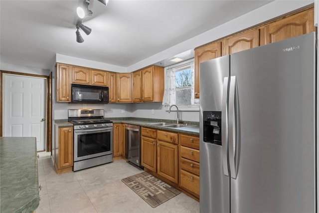 kitchen featuring stainless steel appliances, rail lighting, and sink