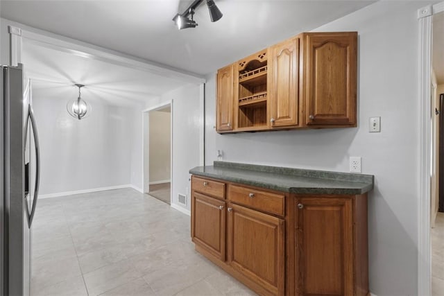 kitchen with track lighting, stainless steel fridge, and an inviting chandelier