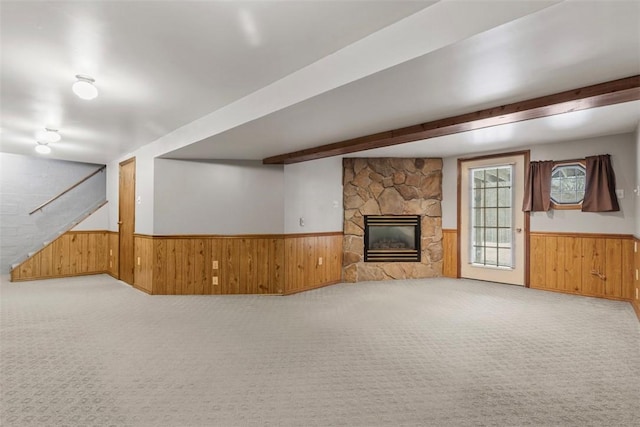 unfurnished living room with a stone fireplace and light colored carpet