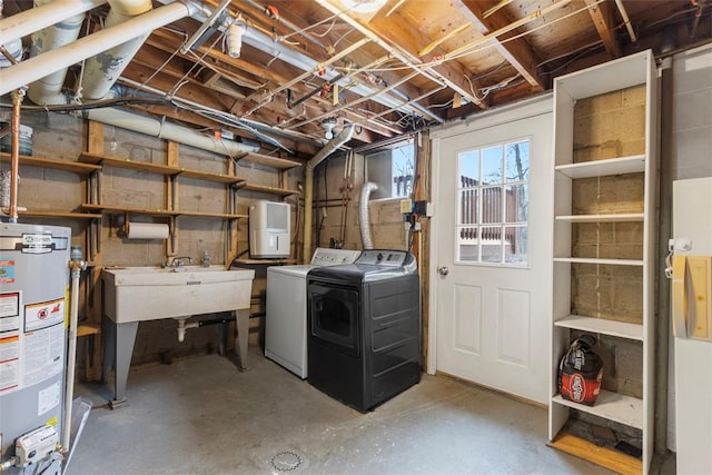 basement featuring washer and clothes dryer, sink, and gas water heater