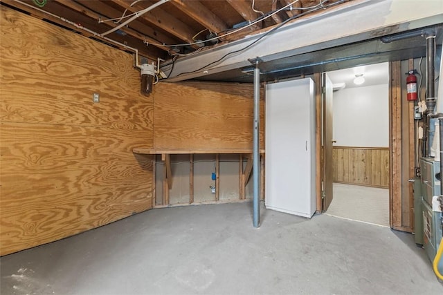 basement featuring wooden walls