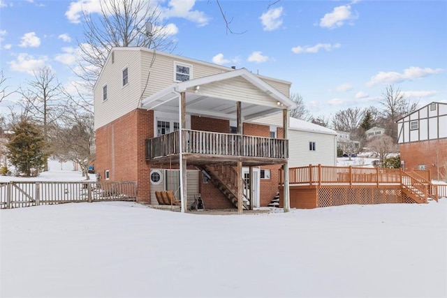 snow covered rear of property with a wooden deck