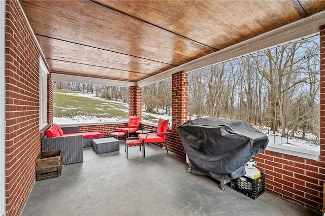 snow covered patio featuring an outdoor living space and a grill