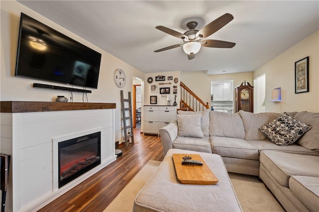 living room featuring ceiling fan and dark hardwood / wood-style floors