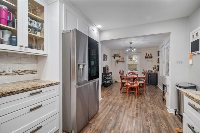 kitchen featuring white cabinets, backsplash, dark hardwood / wood-style flooring, and stainless steel fridge with ice dispenser