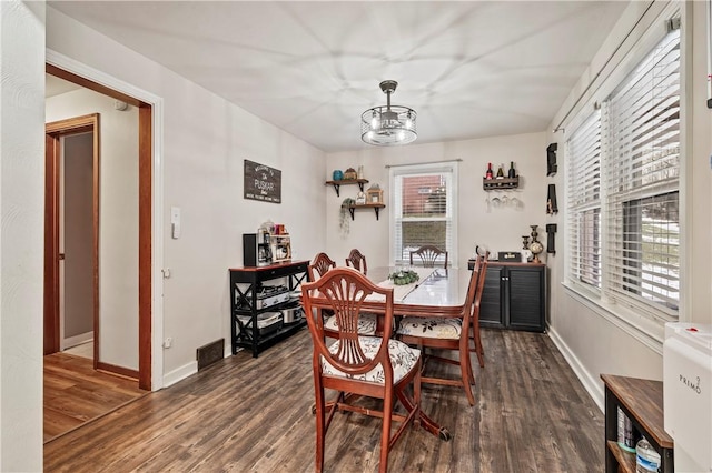 dining room featuring dark hardwood / wood-style floors and a chandelier