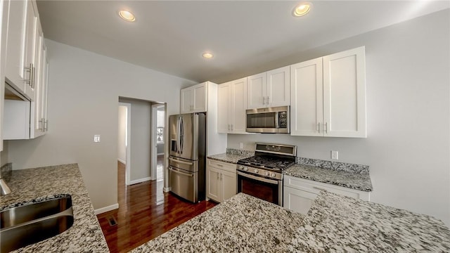 kitchen featuring white cabinetry, stainless steel appliances, light stone countertops, and sink