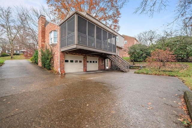 view of home's exterior featuring a garage and a sunroom