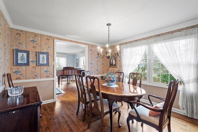 dining area featuring an inviting chandelier, crown molding, and hardwood / wood-style flooring