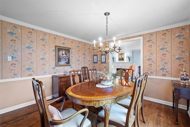 dining area featuring dark wood-type flooring, ornamental molding, and an inviting chandelier