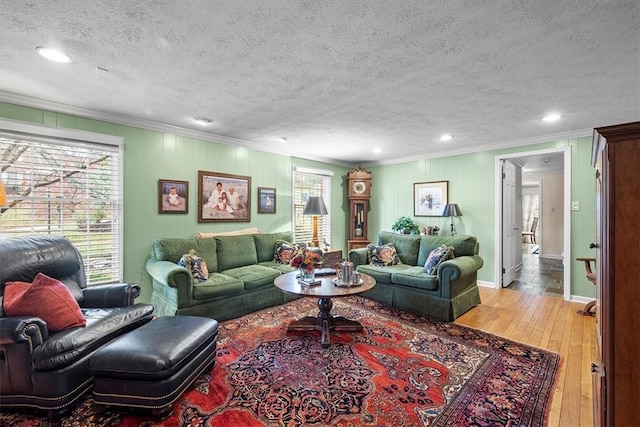 living room featuring crown molding, a textured ceiling, and light hardwood / wood-style flooring