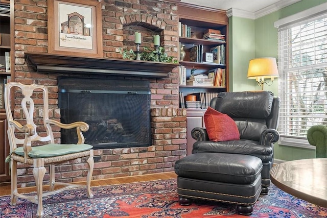 living area featuring crown molding, hardwood / wood-style floors, and a fireplace