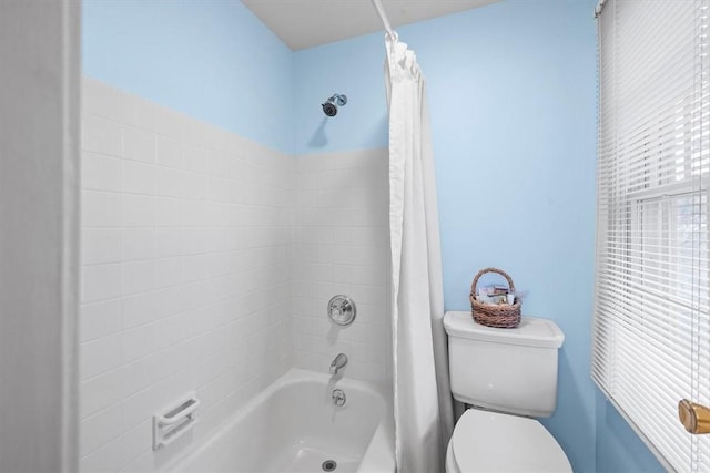 bathroom featuring shower / tub combo with curtain and toilet