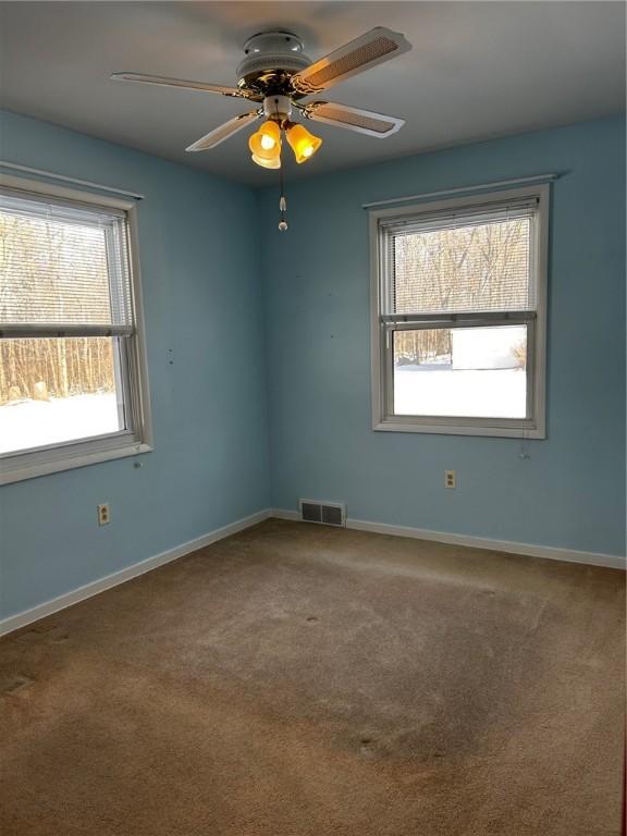 carpeted spare room featuring ceiling fan