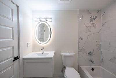 full bathroom featuring vanity, toilet, and tiled shower / bath