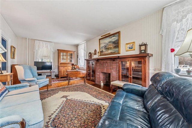 living room featuring hardwood / wood-style floors and a brick fireplace