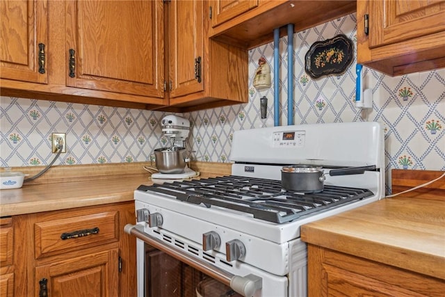 kitchen with tasteful backsplash and white gas range