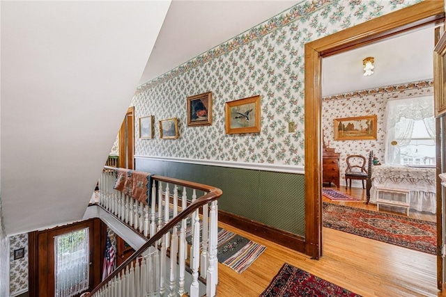 corridor featuring hardwood / wood-style flooring and vaulted ceiling