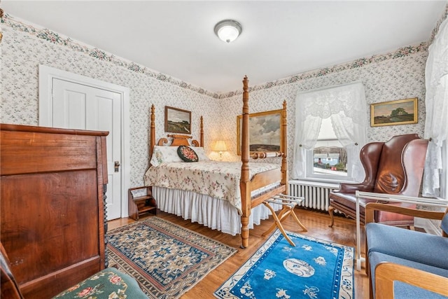 bedroom with hardwood / wood-style flooring and radiator heating unit