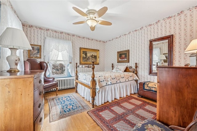 bedroom featuring ceiling fan, radiator, and light wood-type flooring