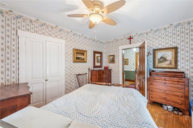 bedroom with wood-type flooring, ceiling fan, and a closet